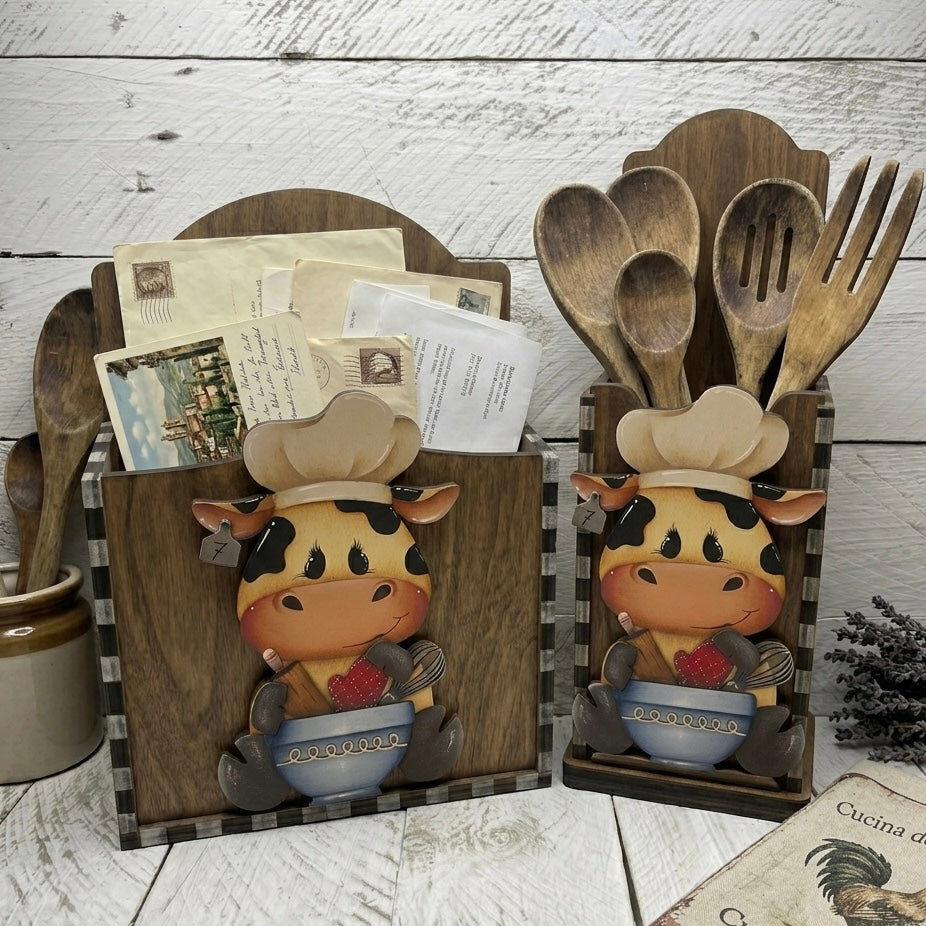 Mucca seduta con utensili da cucina (Copia) Out of the Wood